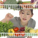 Lady looking at vegetables in fridge
