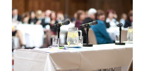 image of conference with microphones on table